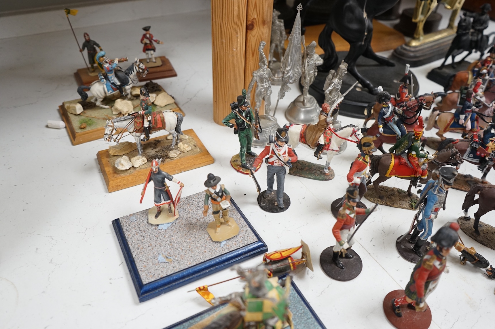 A pair of spelter figures a brass door stop two models of horses two other figures and a large group of toy soldiers. Tallest 45cm.